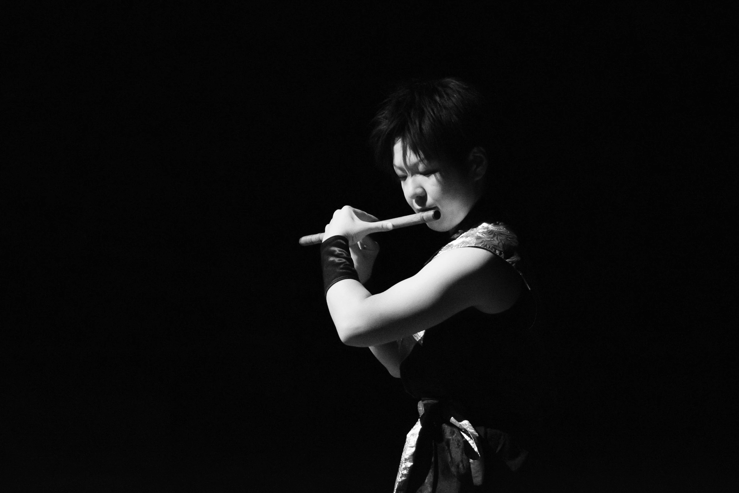 black and white image of a person wearing karate gear and holding a bat