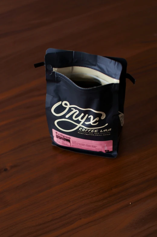 a bag on a wooden table with a pink strip