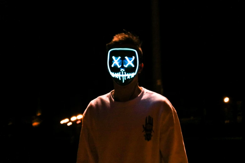 man wearing a neon mask at night