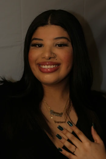 smiling woman with black and blue manicures wearing a necklace