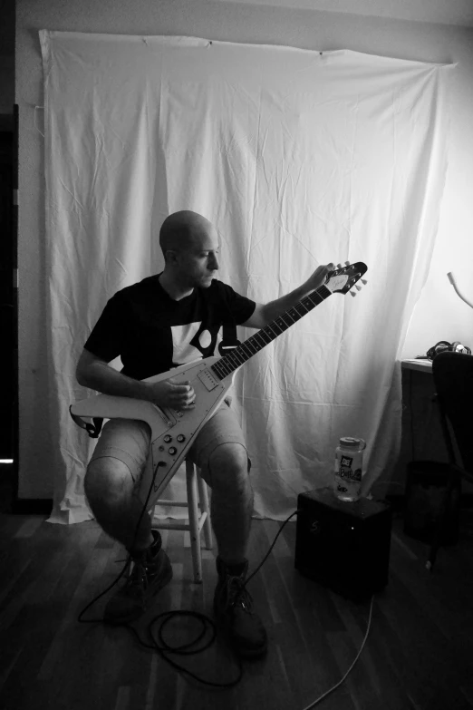 a man sitting in a chair holding a guitar