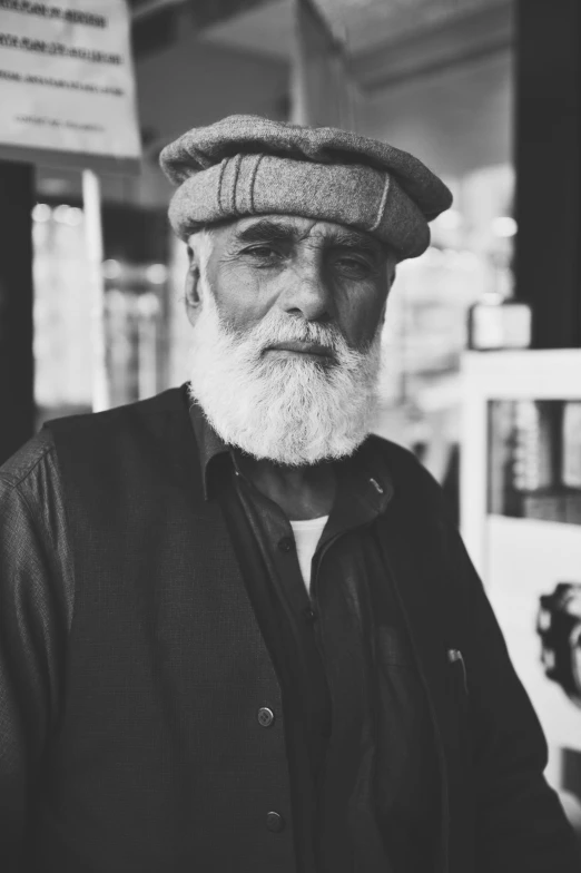 man in hat looking at camera while standing by water pump