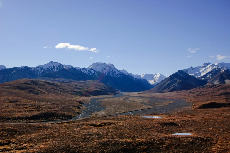 a large open area with some water and mountains in the background