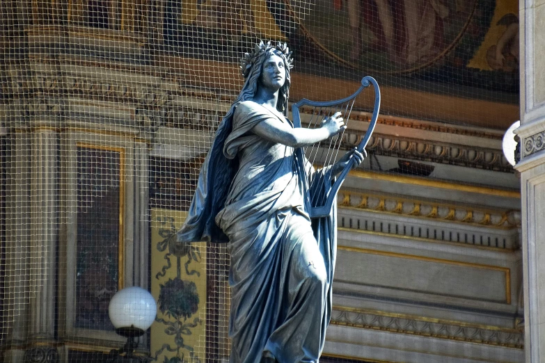 an statue on the outside of a building with a long arrow