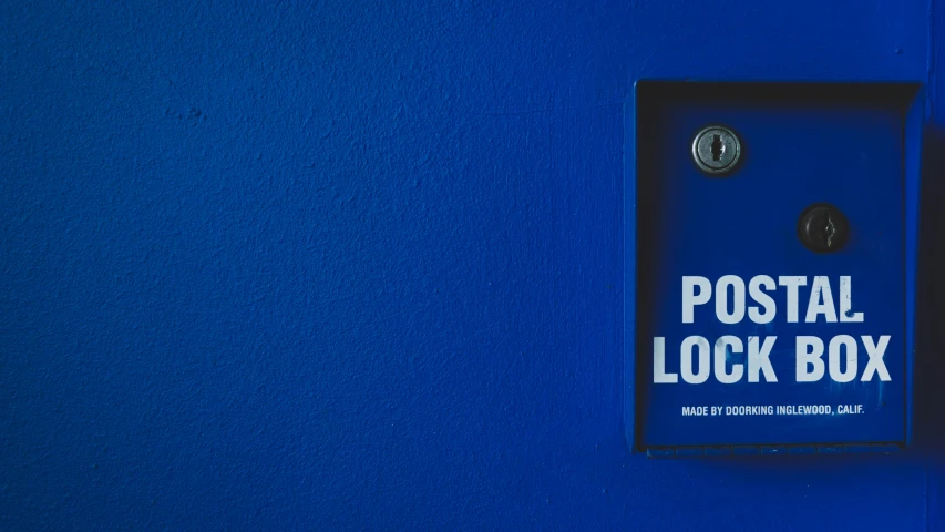 a blue door with the word postal lock box hanging off it