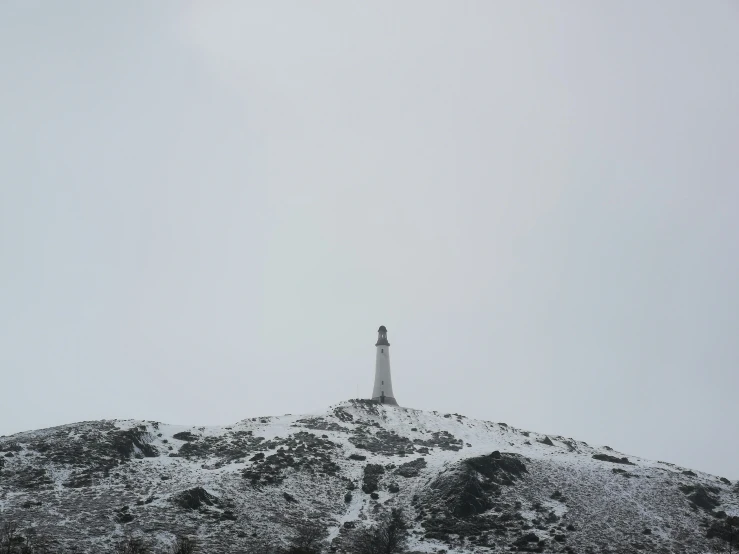 there is a white light tower on the hill