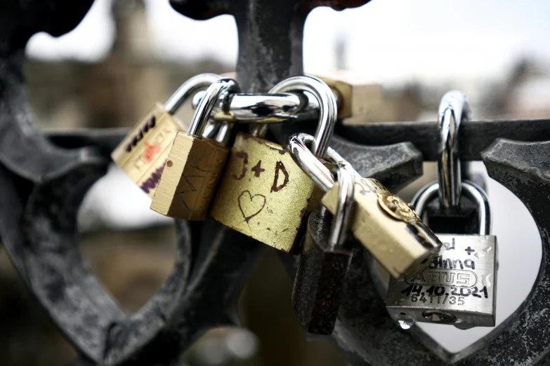 four locks are attached to a gate with an inscribed message on it