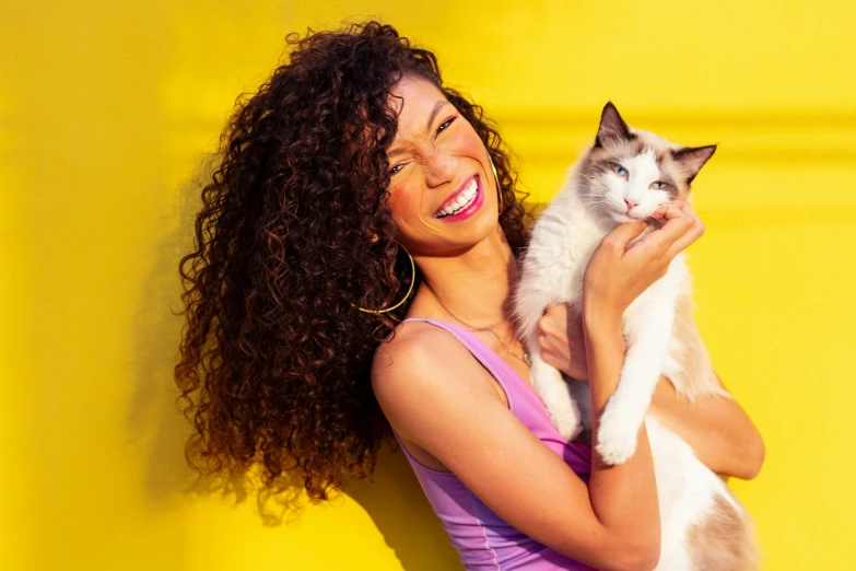 a woman is holding a cat in her arms