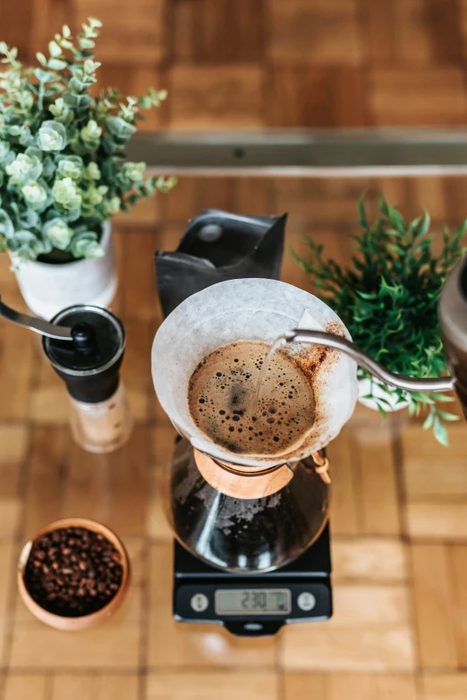 there is coffee being poured into a small pot