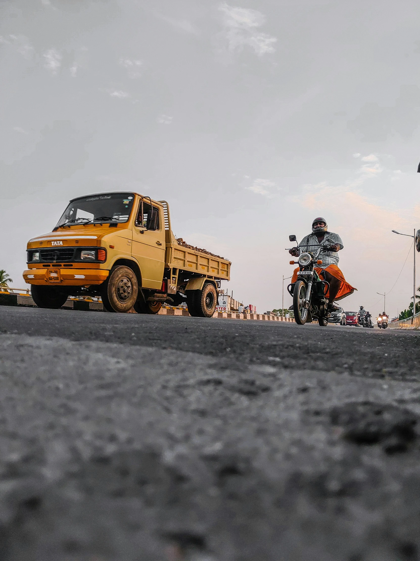 three people riding motor bikes in the street