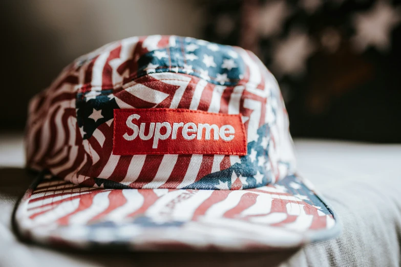 a hat with red and white stripes and a supreme tag