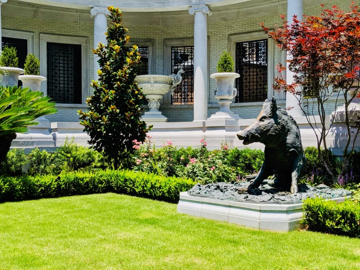 an elegant building with a large bear statue in the yard