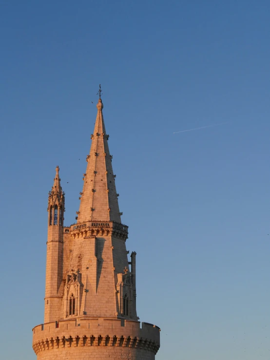 an architectural spire of a stone building with a clock