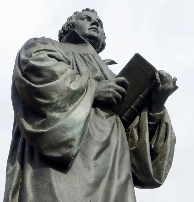 a statue of an old man with a book