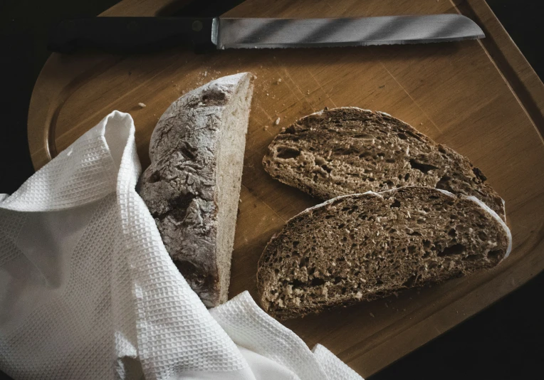 two loaves of bread on a wooden  board