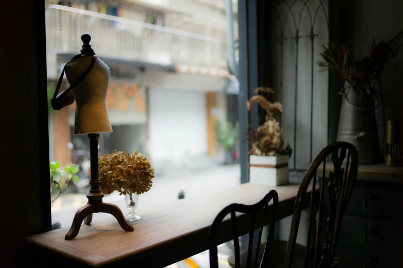 a table in front of a window with a dressmaker's dummy on it