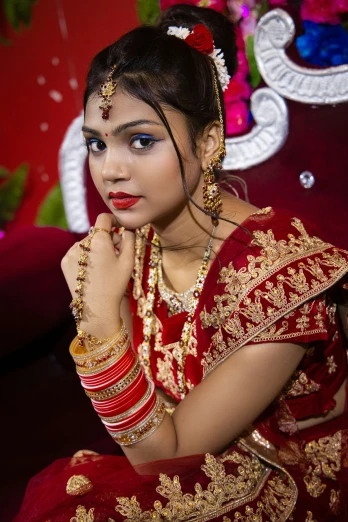 a bride in red sitting on her wedding day