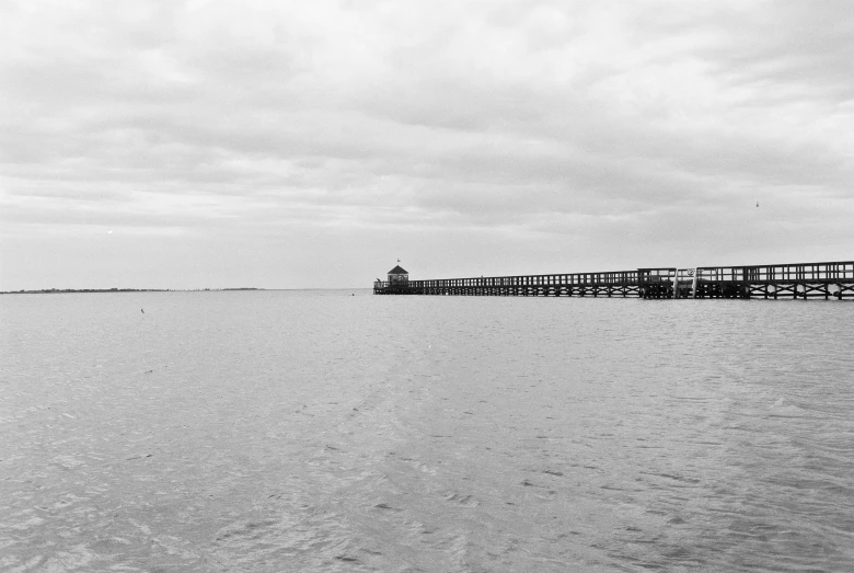 a long pier extends out into the open ocean