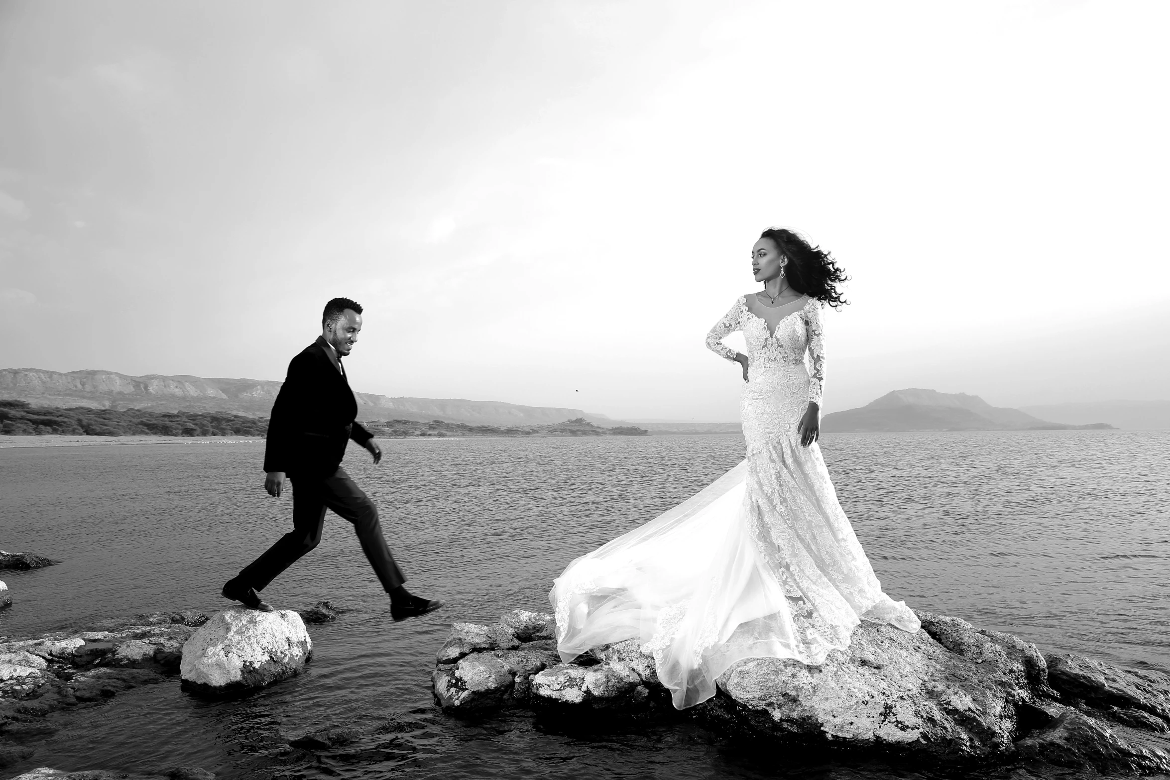 the bride and groom are running around the beach on their wedding day