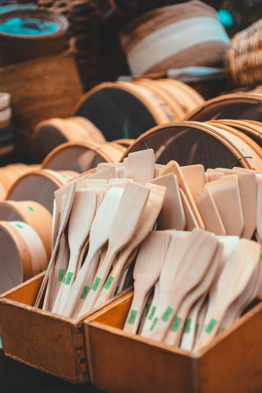 wooden bowls, wrapped in brown paper, are arranged inside a cardboard box