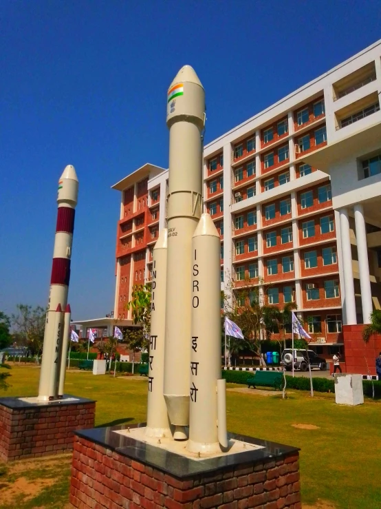 two rockets on display outside of a large building