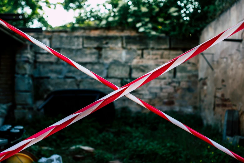 a view of a house, through a pair of red scissors with white tape