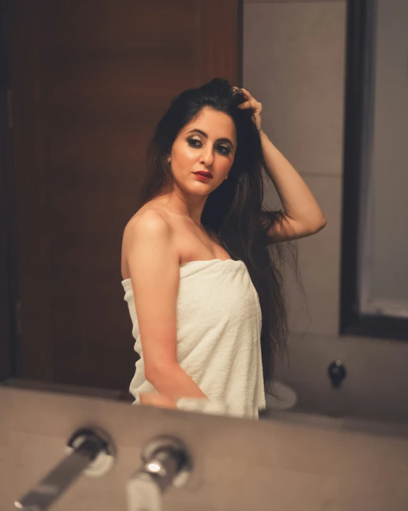 woman in white towel standing in front of sink