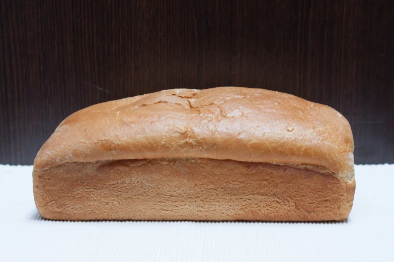 a loaf of brown bread on a white surface