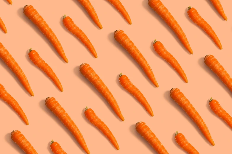 a bunch of carrots are arranged on an orange background