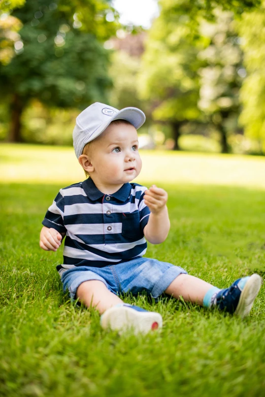 a small toddler is sitting in the grass