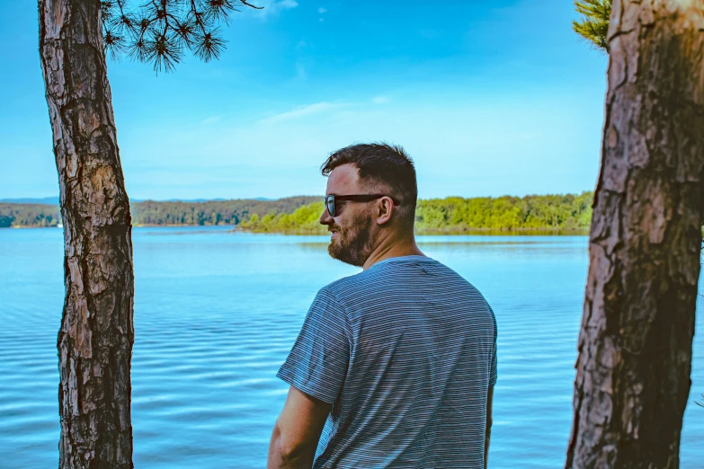 a man stands on the dock by some trees