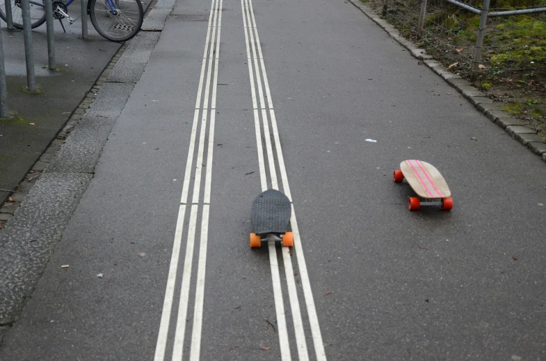 two skateboarders ride along a city street