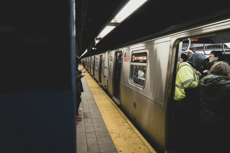 many people crowded on a subway platform in the dark