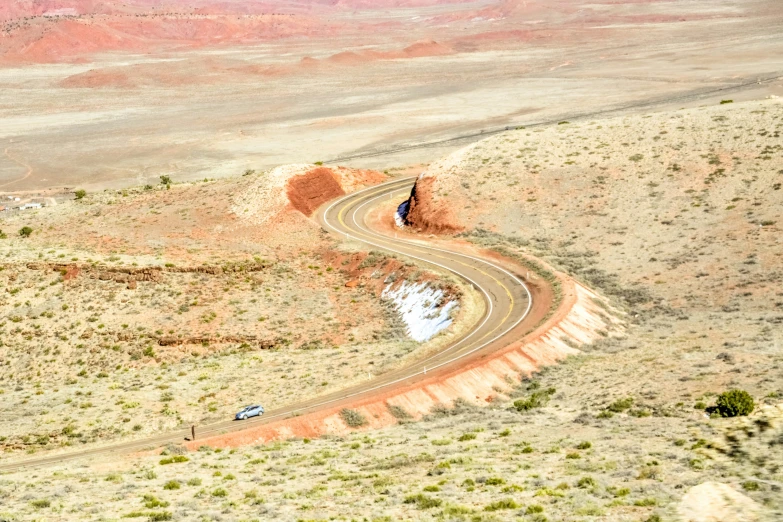 the vehicle drives down the road in the desert