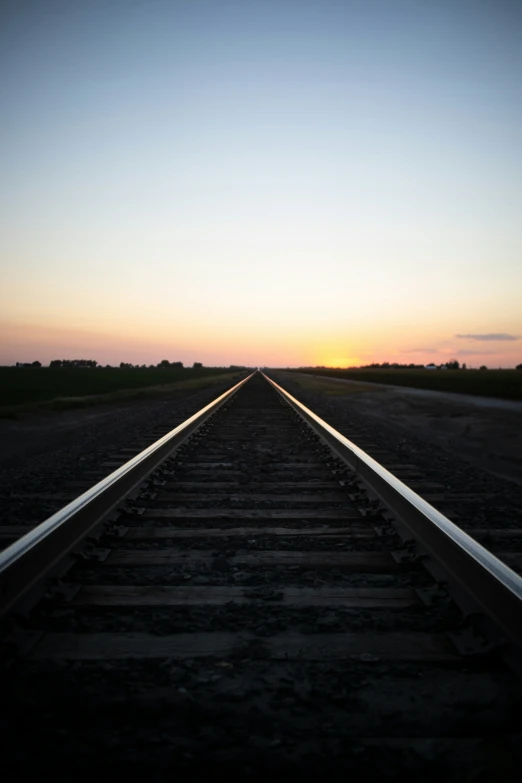 the sun sets on train tracks, with no trains at all