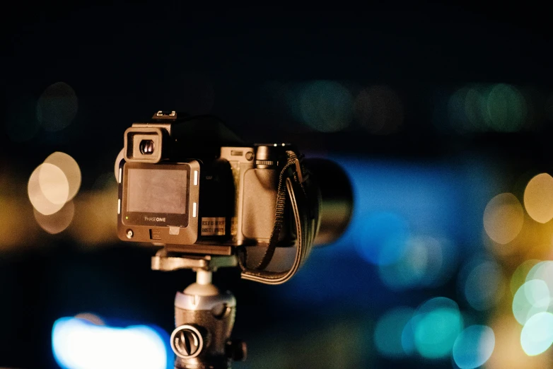 the camera is sitting on the tripod near a building