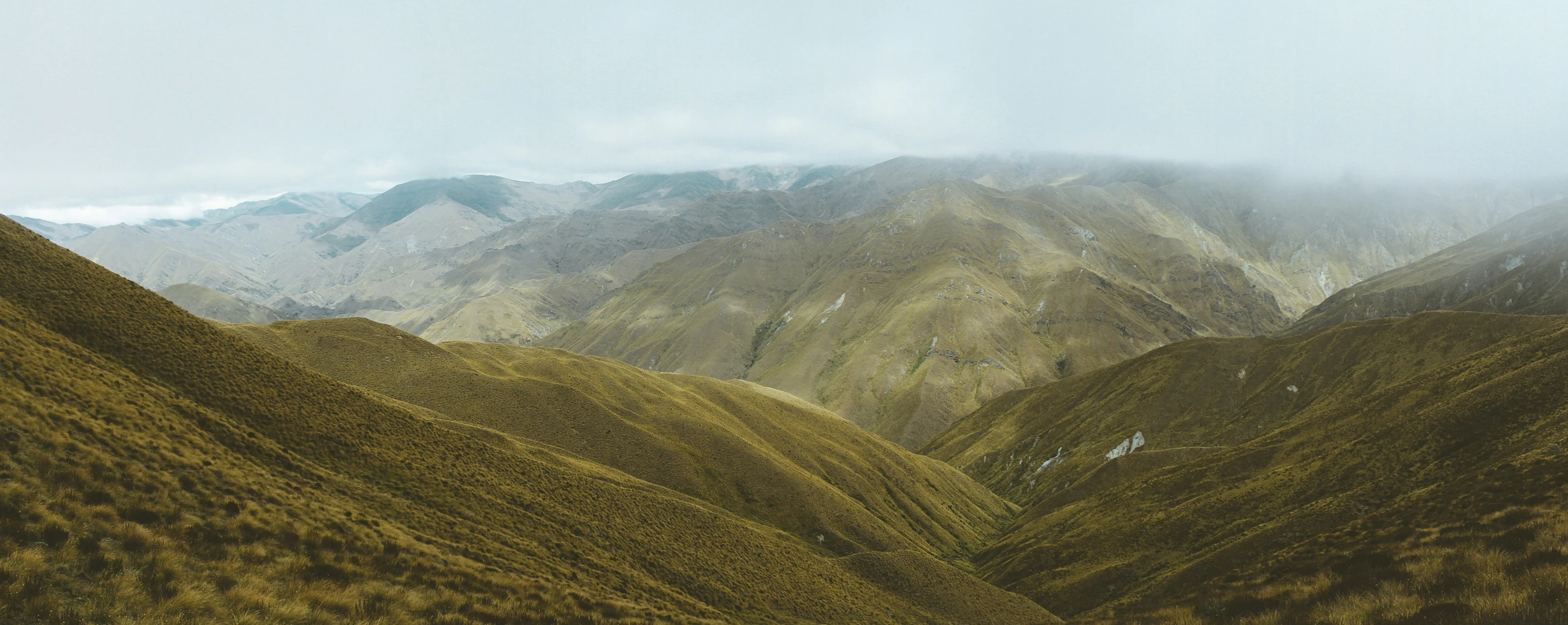 a mountain range covered in grass and hills