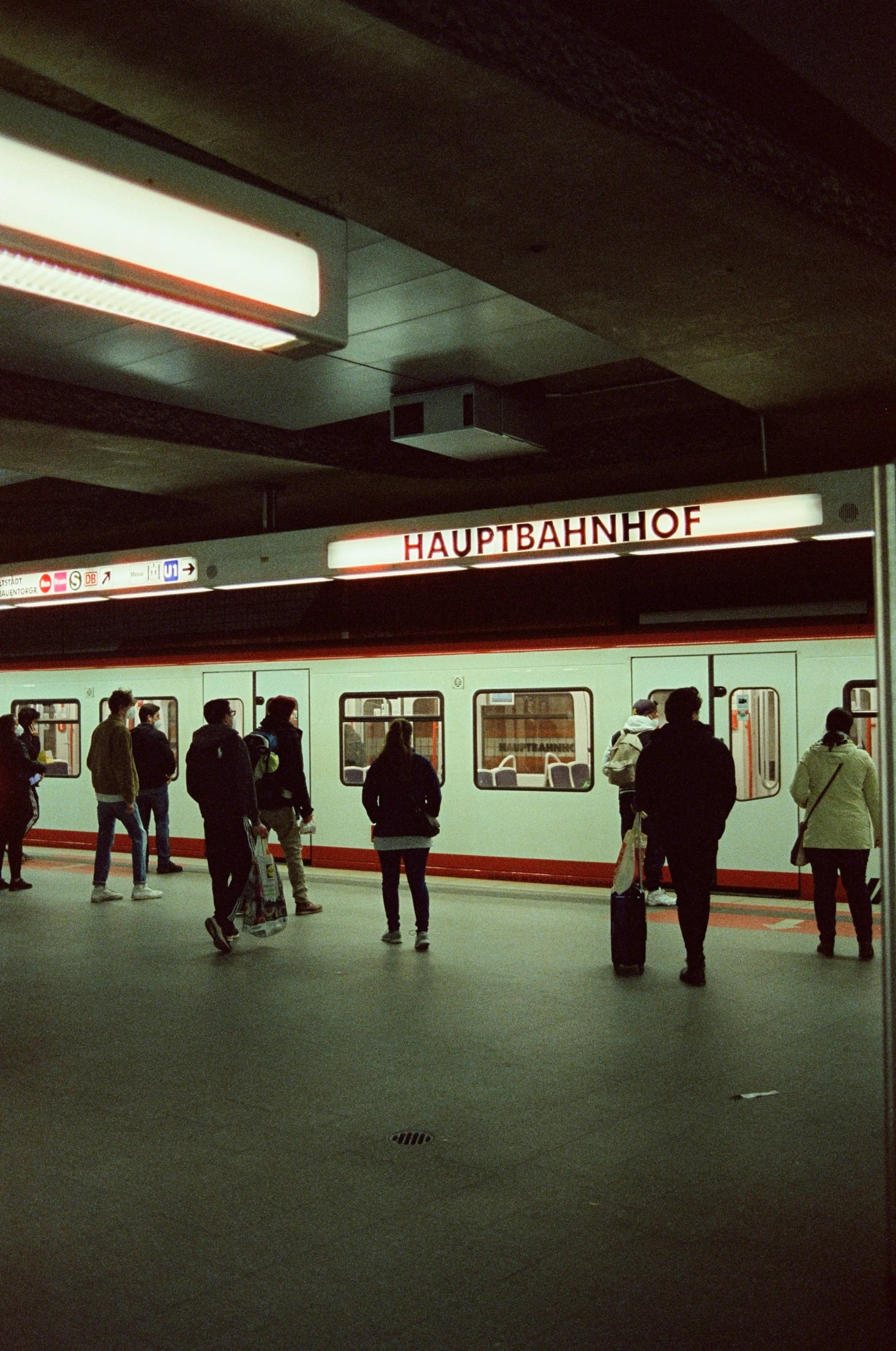 people standing near a subway stop in the dark