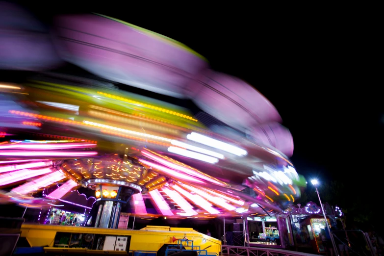 a carnival ride lit up by lights with colorful lights