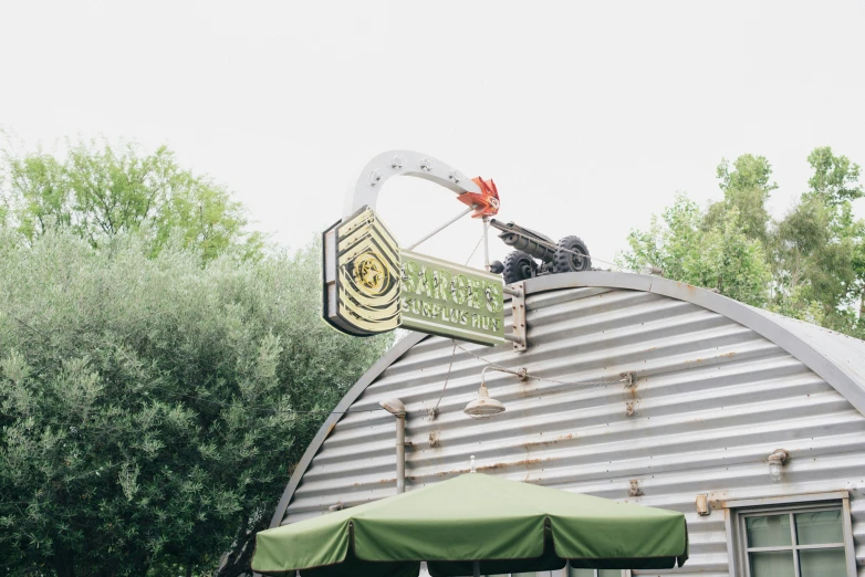 a building with a large green umbrella on the roof and a sign on top