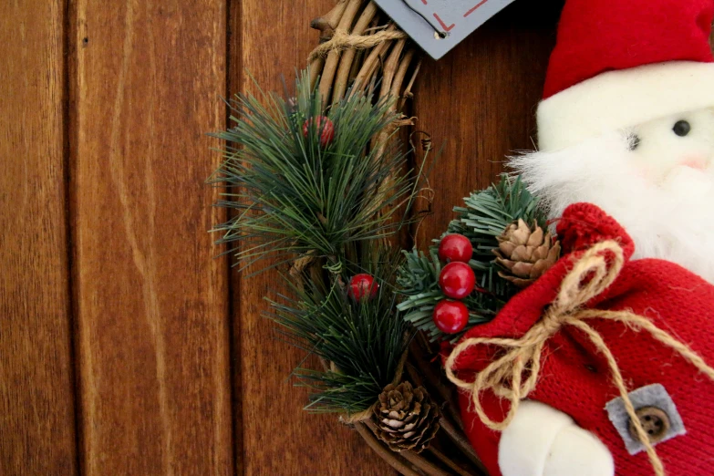 a christmas wreath with a small santa claus doll