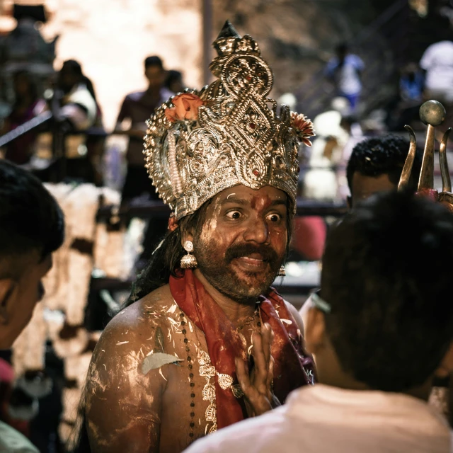 a man in costume and facial paint wearing headdress