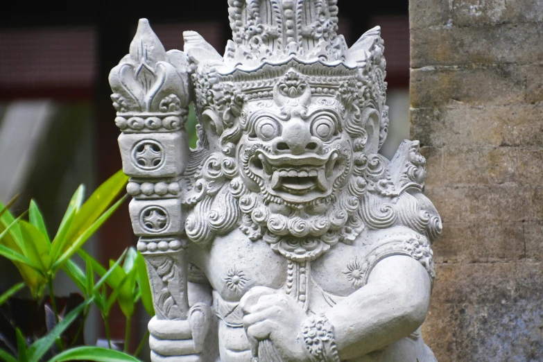 a statue sitting on top of a cement pillar