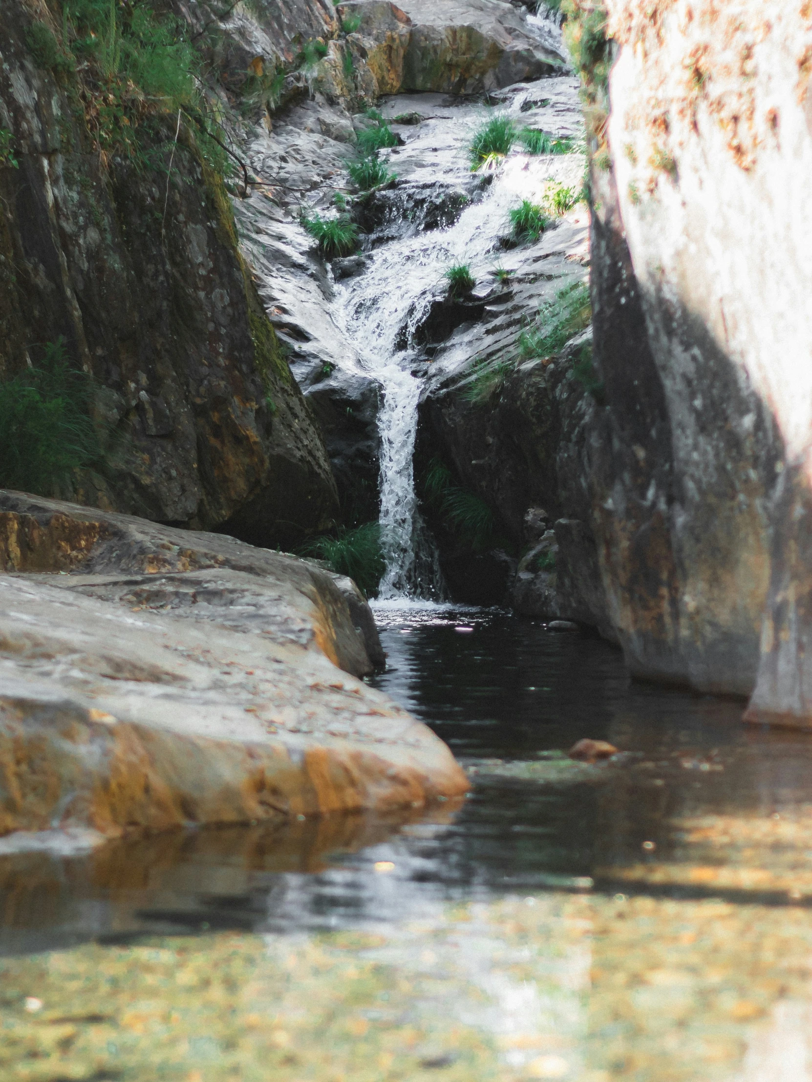 the waterfall near some very large rocks and water