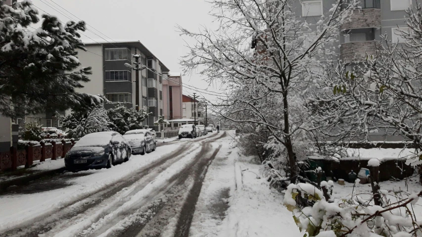 an old po with snow on it with a road lined by apartment buildings