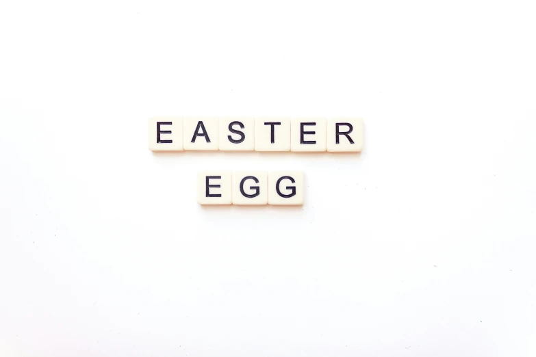 the word easter egg spelled with scrabble blocks on a white background