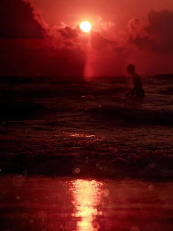 the sun shining brightly on the ocean as a surfer catches waves