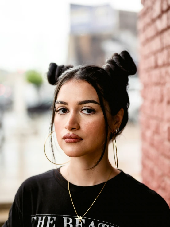 a woman with her hair up in a bun wearing a shirt