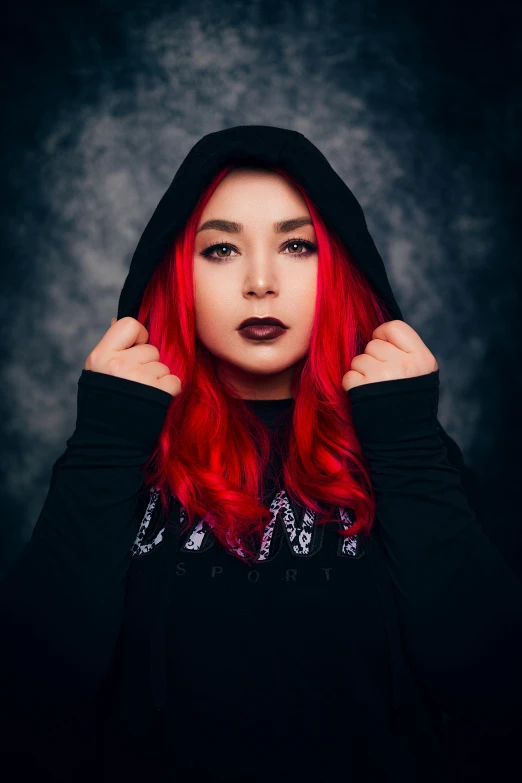 a woman with red hair wearing a hoodie over her shoulders