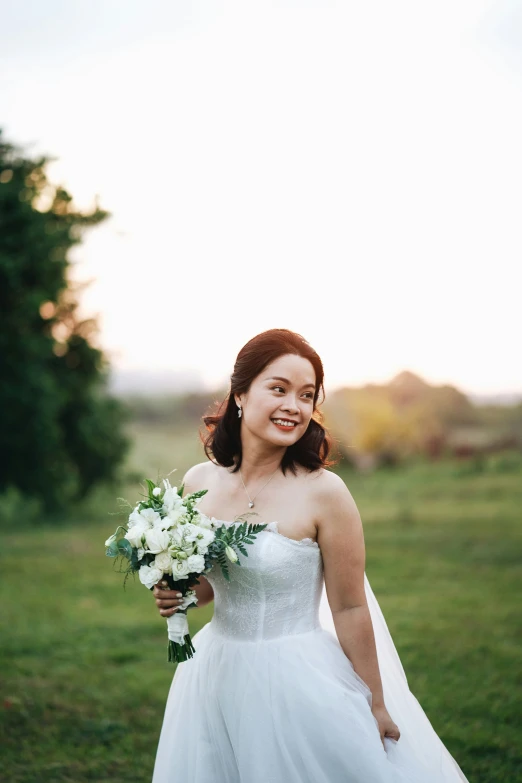 the bride is standing in the green field